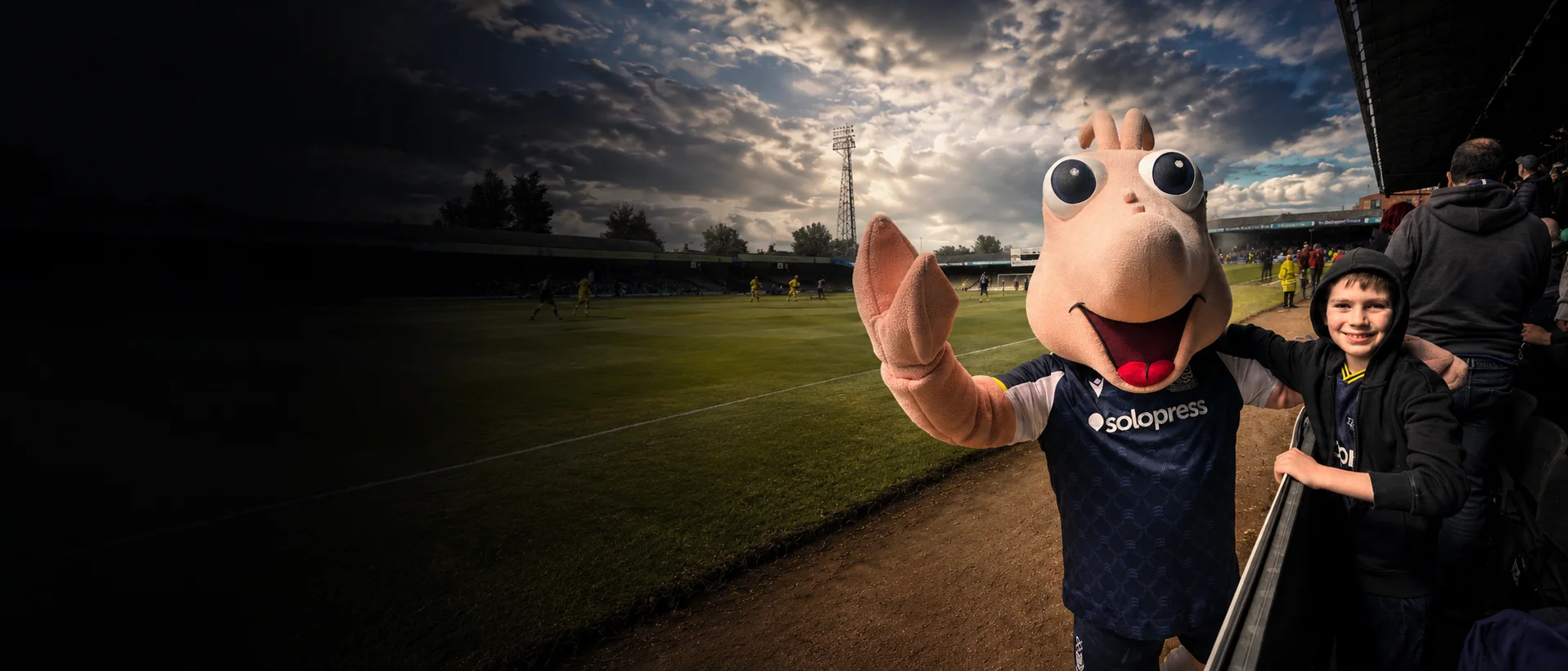 The Southend United mascot greeting a young supporter beside the pitch