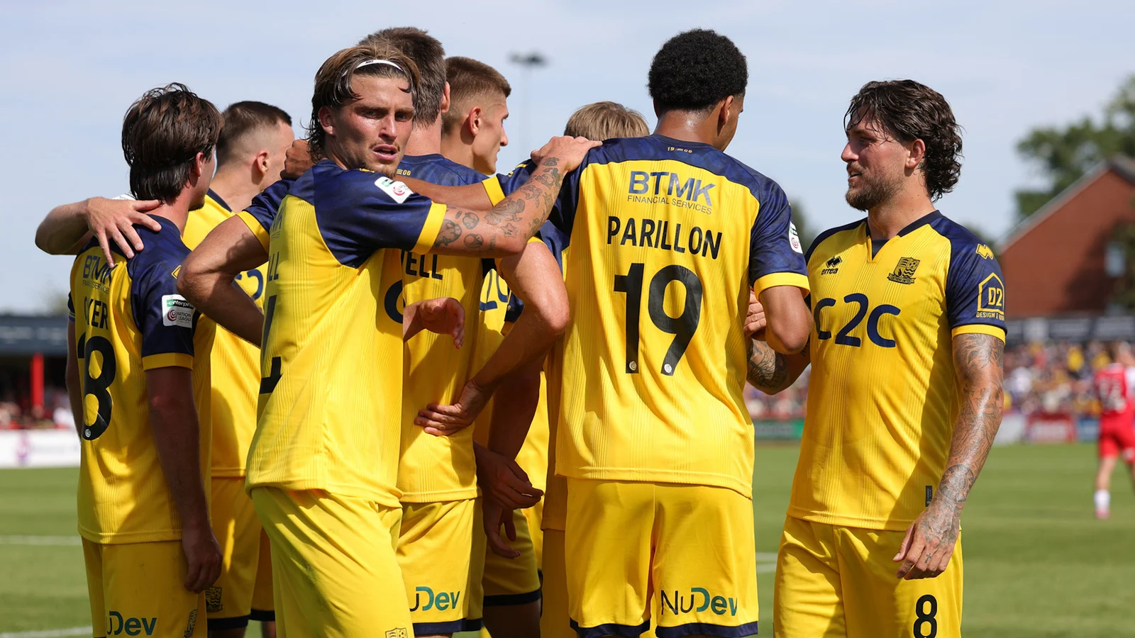 Southend United players celebrate together in their yellow away kit after scoring at Altrincham.