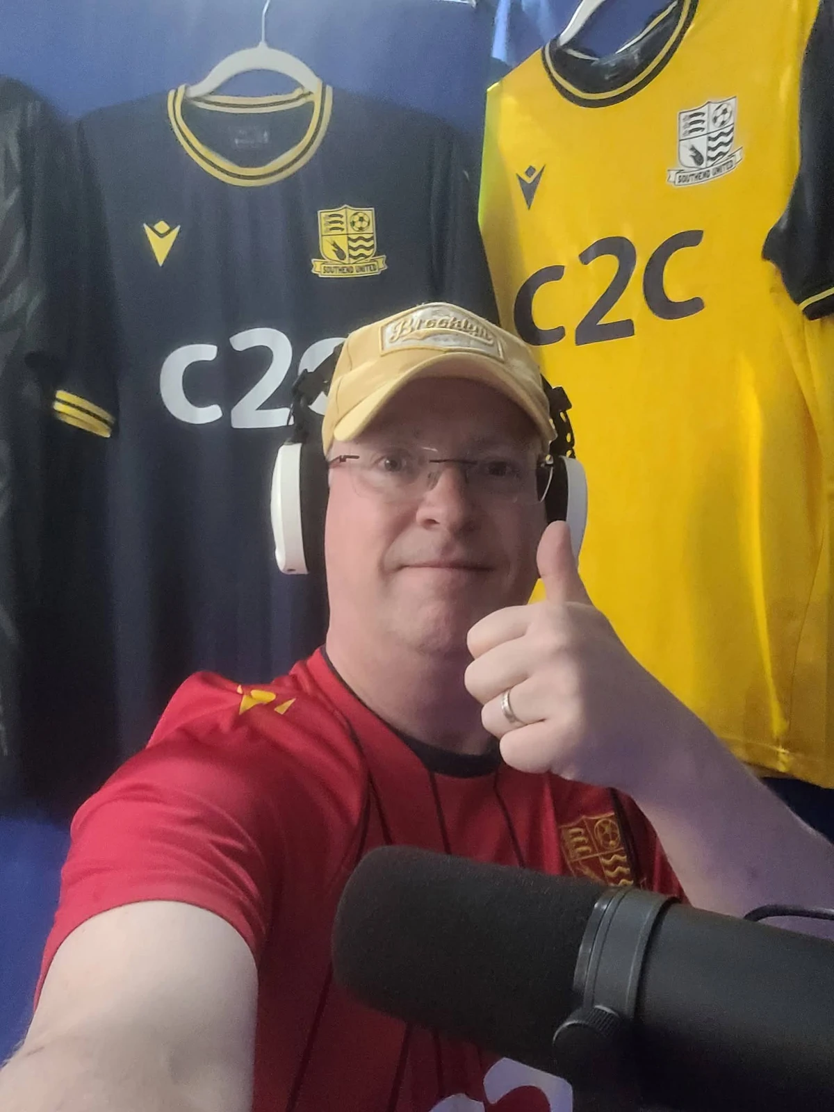 Sensei Phil records the podcast at home, wearing headphones with Southend shirts behind him.