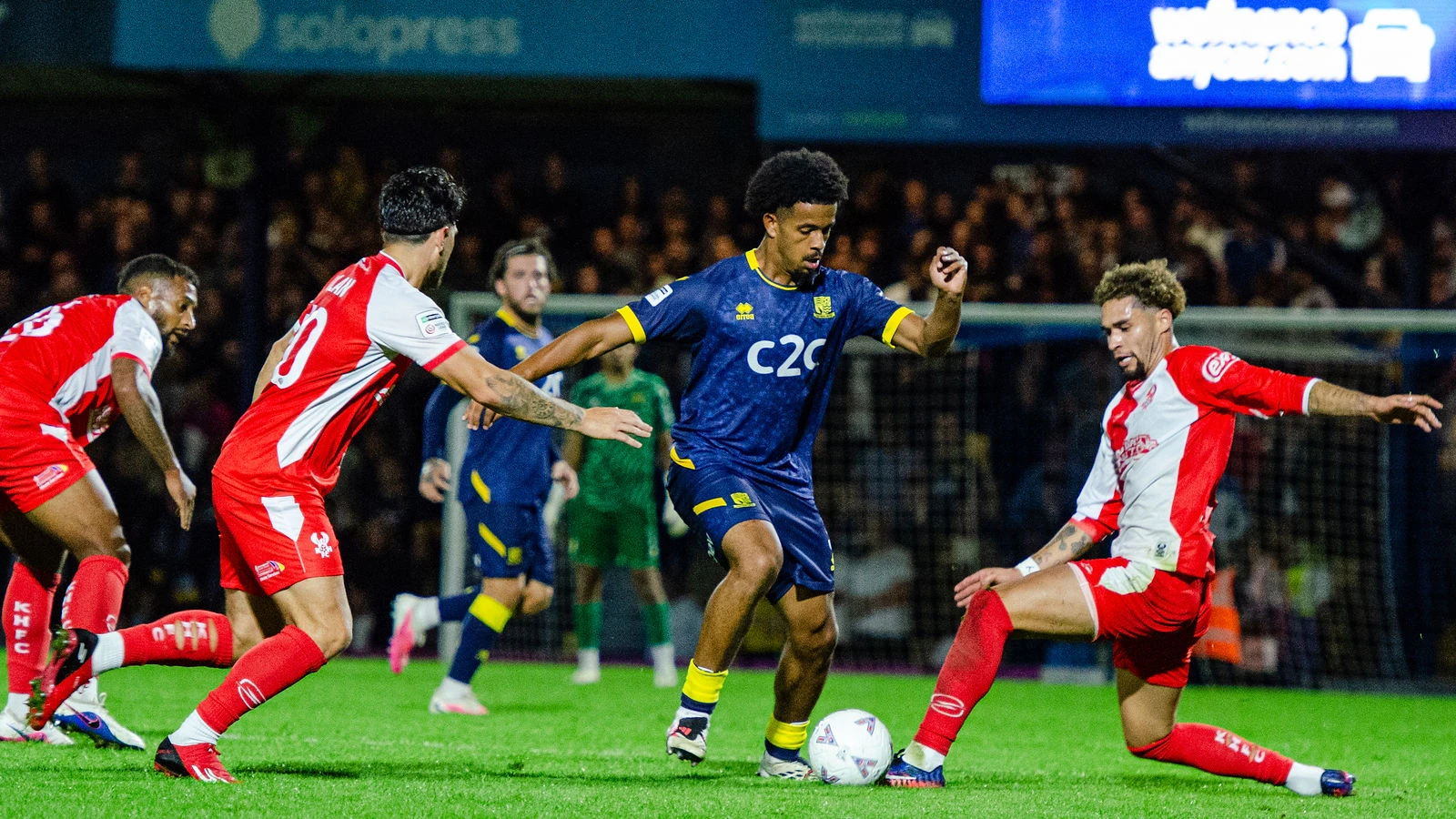 A Southend United player dribbles between Kidderminster Harriers defenders at Roots Hall.