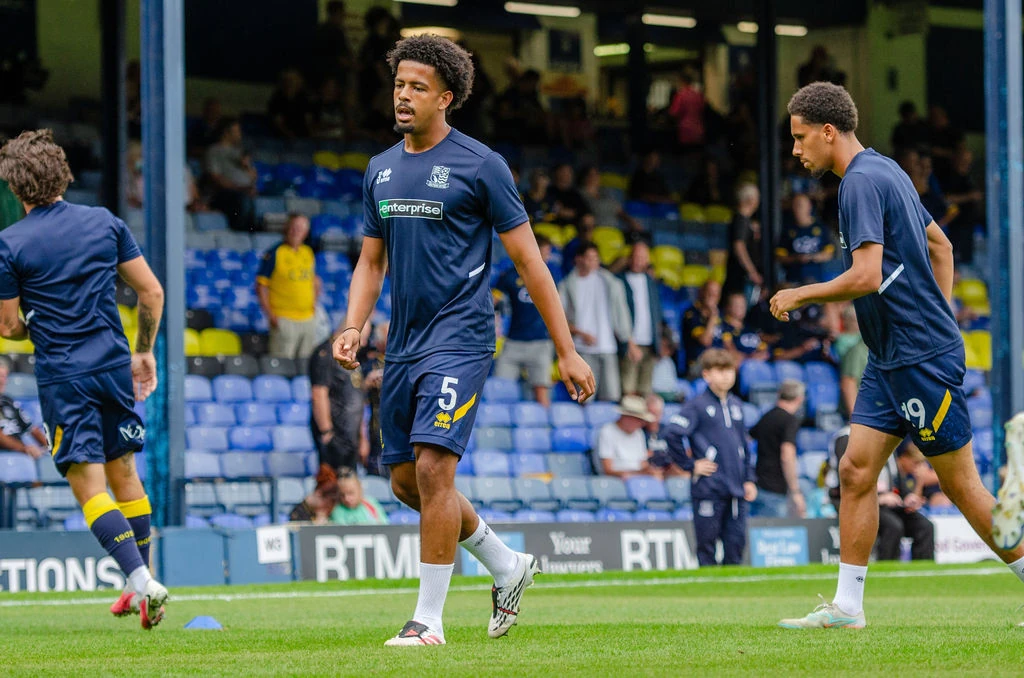 Three Southend players warm up on the Roots Hall pitch.