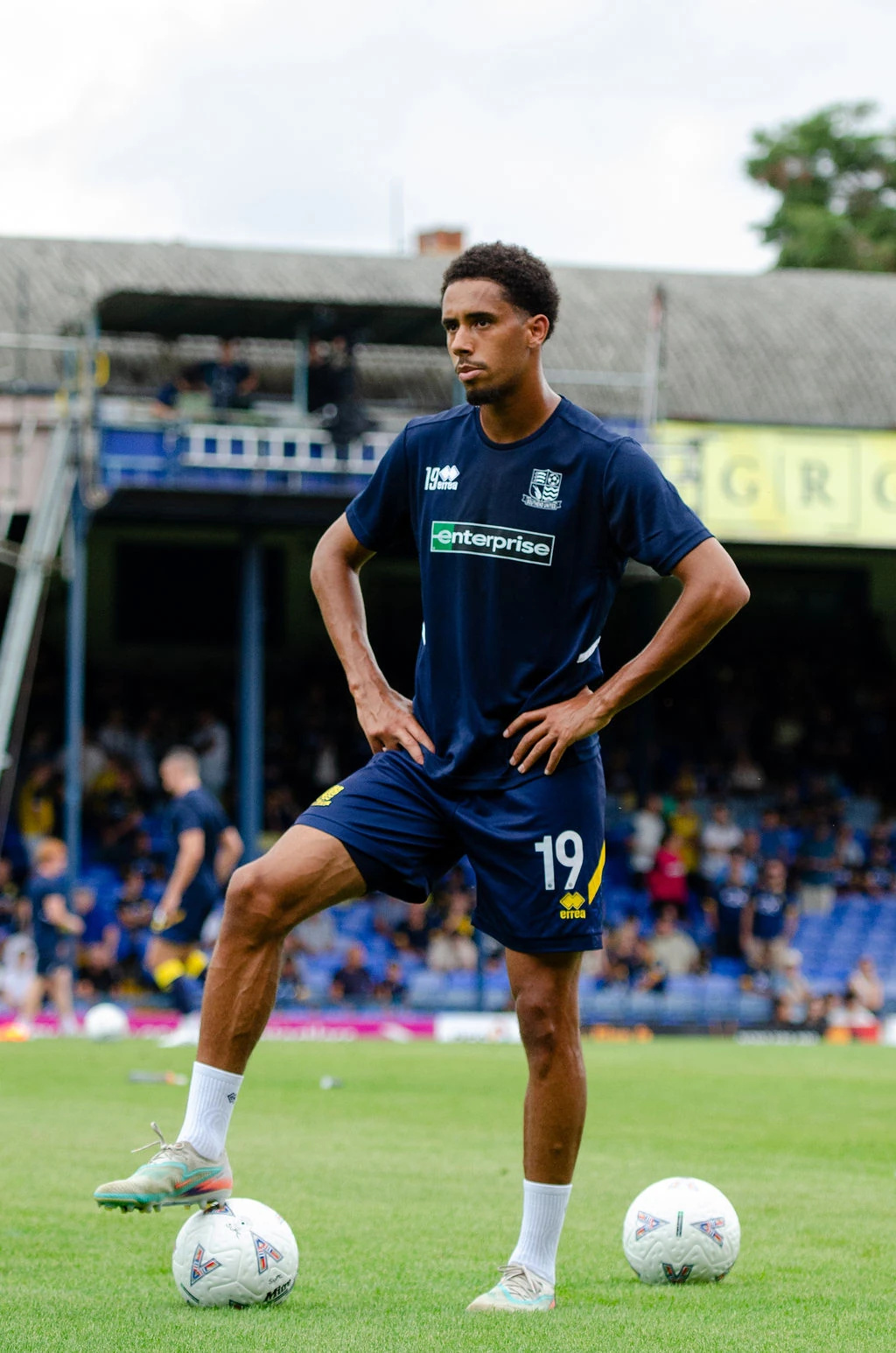 Southend player stands with one boot resting on a ball during the warm-up.